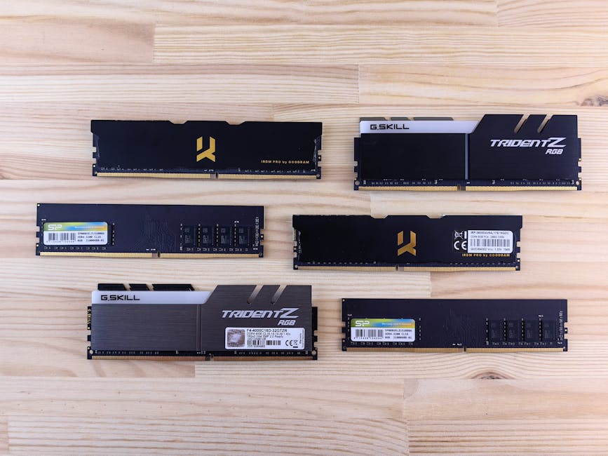 AI Datacenter Pullback Could Finally Cool RAM Prices 1 Top view of various RAM sticks arranged on a wooden surface, showcasing computer memory technology.