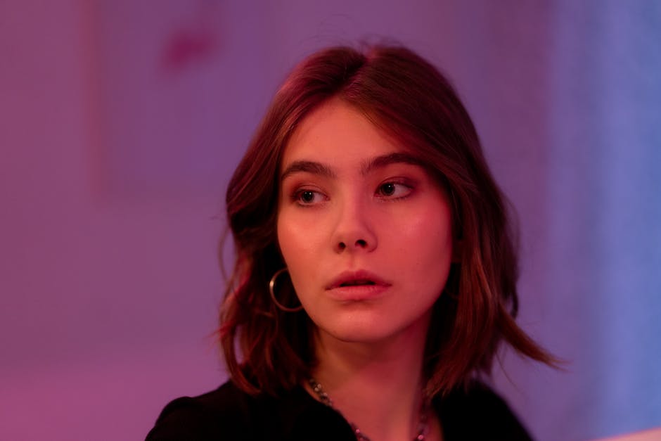 Euphoria Season 3 Time-Jumps Five Years, Chaos Stays 1 A captivating portrait of a woman with short hair and hoop earrings, surrounded by soft lighting.