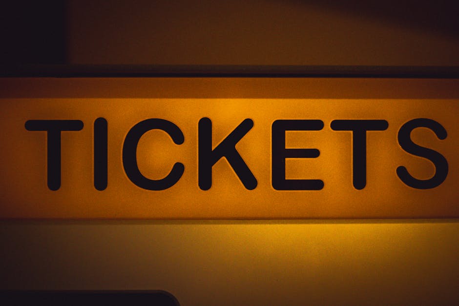 Live Nation Ruling Raises Stakes for Ticketmaster’s Future 1 Close-up of an illuminated yellow ticket sign against a dark background.